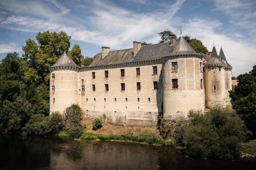 Le château-hôtel Le Relais de Touraine à Abilly, France, avec ses tours en pierre se reflétant dans la rivière
