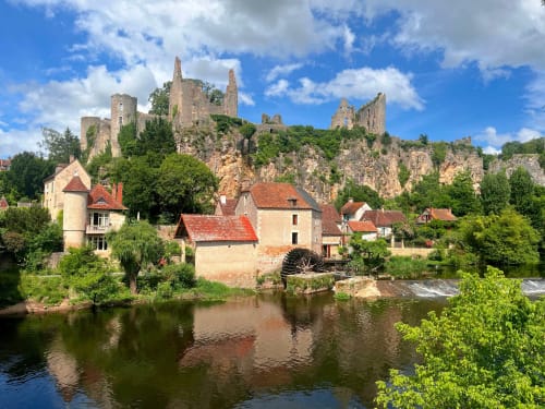 Ruines d'un château médiéval perchées sur des falaises rocheuses surplombant l'hôtel Le Relais de Touraine à Abilly, France, avec moulin au bord de la rivière