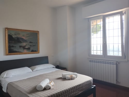 Camera moderna a Travellers Homes a Campagnano di Roma con letto, quadro di mare e finestre luminose affacciate sulla