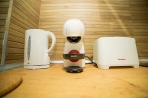Electrodomésticos blancos en apartamento Las Arenas: hervidor eléctrico, cafetera y tostadora sobre encimera de madera