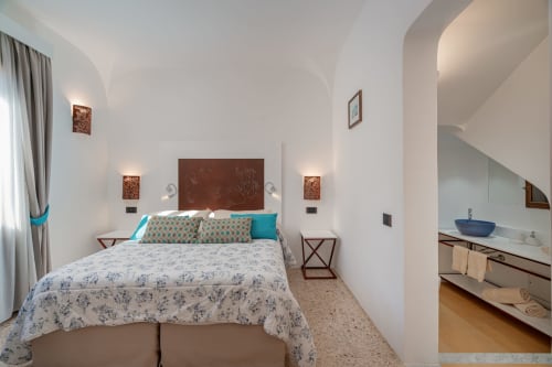Camera moderna di Short Let's Olbia con accenti turchesi, soffitti arcuati, bagno privato e illuminazione calda