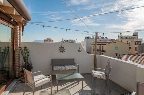 Terrazza panoramica di Short Let's Olbia con sedute, piante in vaso e vista sulla città di Olbia