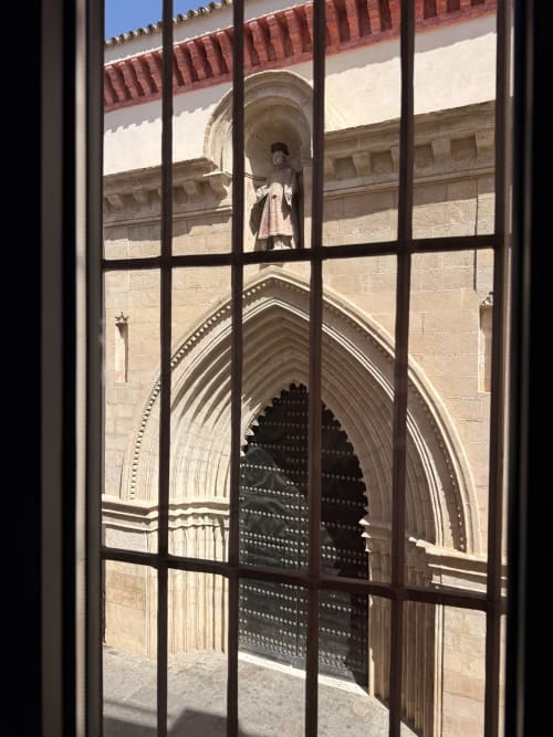 Vista de la portada gótica de la catedral desde la ventana del hotel de Sevilla con arco ornamentado y estatua superior