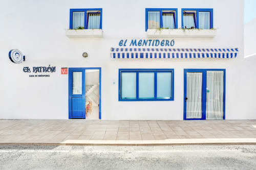 Casa de Huéspedes El Patrón a El Cotillo con finestre e porte bordate di blu su facciata bianca