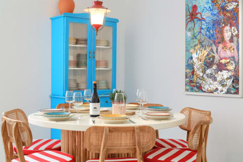 Sala da pranzo colorata di El Patrón Casa de Huéspedes a El Cotillo con tavolo rotondo, sedie in legno e credenza blu