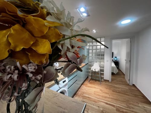 Pasillo moderno en Las Arenas con flores amarillas, pisos de madera e iluminación contemporánea