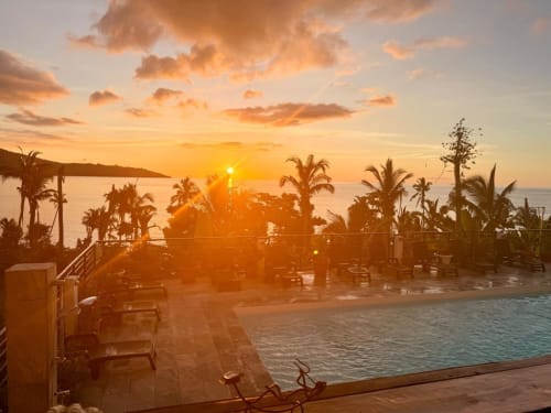 Coucher de soleil sur la piscine de l'hôtel Le Chissioua et palmiers à Sada avec vue sur l'océan