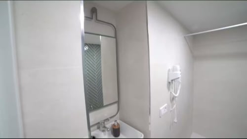 Cuarto de baño moderno en apartamento Las Arenas con ducha de azulejos en espiga y accesorios fijados a pared en València