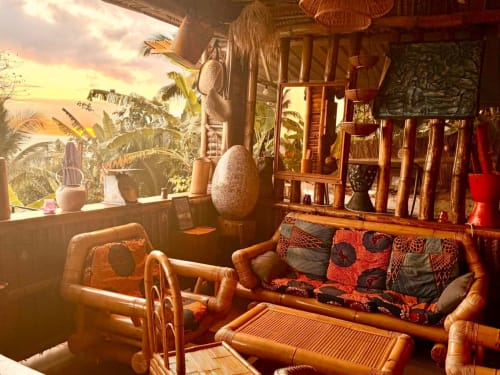 Salon bambou avec décoration tropicale à l'hôtel Le Chissioua à Sada, vue coucher de soleil par les fenêtres
