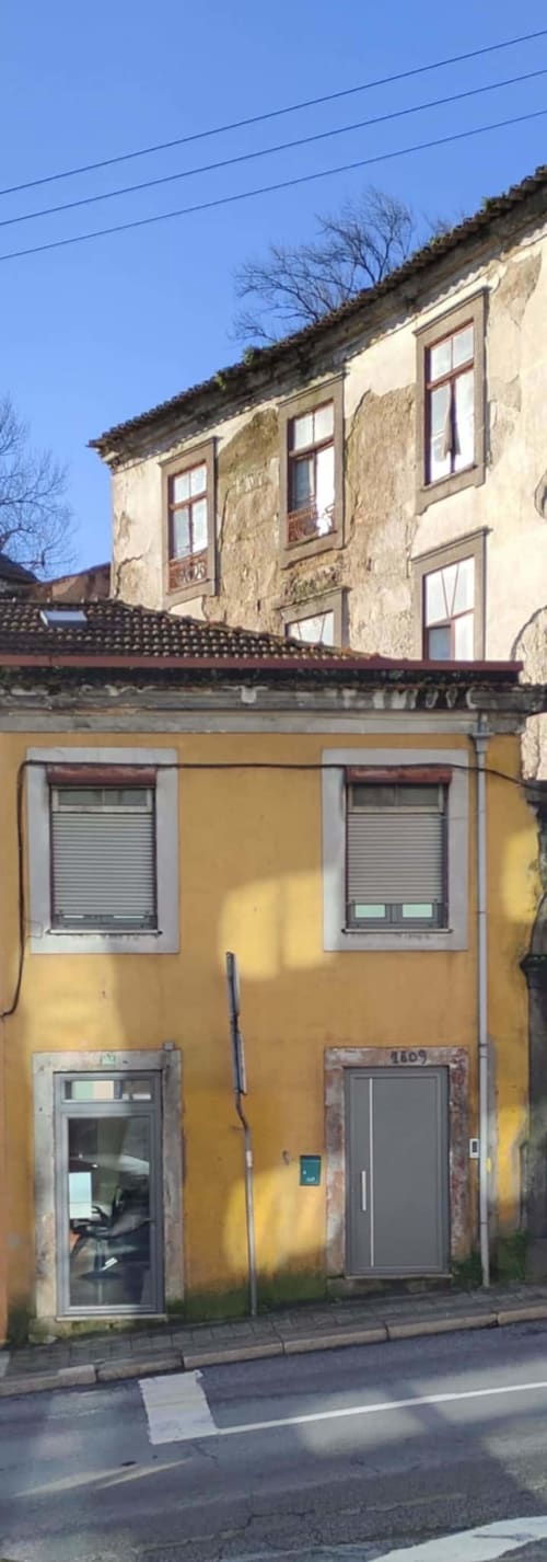 Yellow storefront building in Chaves, PT with traditional stone apartment above, Voluta Management BnB