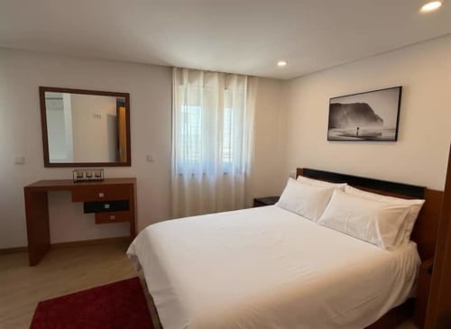 Charming hidden gem apartment bedroom in Chaves with double bed, desk, mirror and balcony overlooking Campanhã