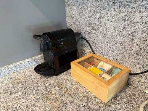 Kitchen counter with black espresso machine and wooden tea organizer box at Voluta Management apartment in Chaves, Portugal