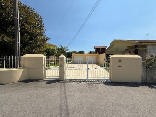 Cream-colored gated entrance to tranquil apartment with garden near Porto, Chaves