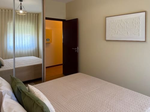 Modern bedroom in Chaves apartment with bed, mirror, and contemporary décor near Porto
