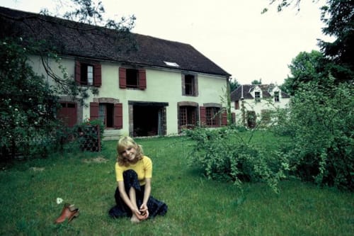 France Gall in the 1960s, sitting in the lush green garden of the Domaine de l'Ocrerie in Pourrain, Burgundy.