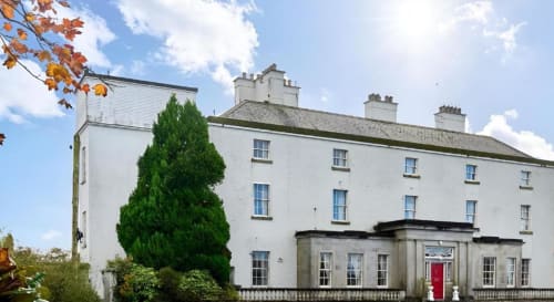 South Hill House, propriété géorgienne blanche à Delvin, Irlande, avec jardins et feuillages automnaux, offrant un gîte
