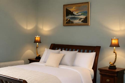 Chambre de la maison d'hôtes South Hill House avec lit en bois, draps blancs, lampes en laiton et tableau marin, Delvin
