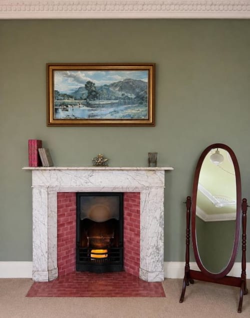 Élégante cheminée avec intérieur en brique rouge et encadrement en marbre à South Hill House, Delvin, ornée d'un tableau et d'un miroir