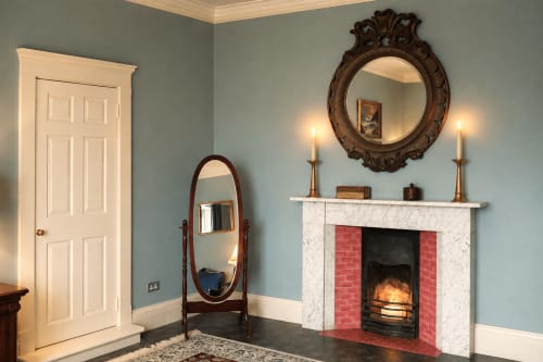 Chambre premium à South Hill House avec foyer entouré de briques rouges, miroirs ornementés, appliques à chandelles, tons crème