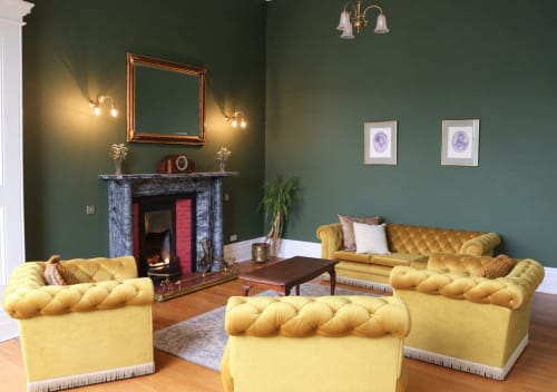 Salon de South Hill House avec canapés Chesterfield dorés, murs verts, cheminée et mobilier d'époque à Delvin