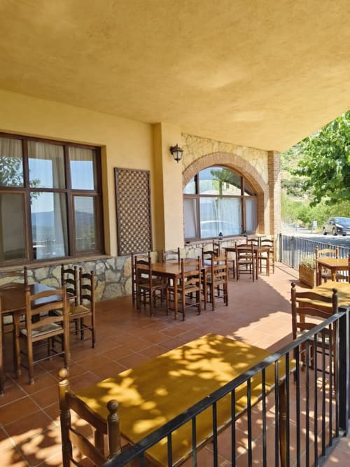 Terraza del Hotel El Balco del Priorat en Tarragona con sillas de madera rústica y vistas panorámicas del valle