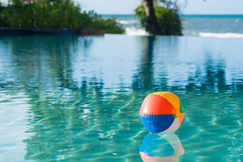 Pelota de playa colorida flotando en la piscina turquesa del Hotel El Balco del Priorat, Tarragona