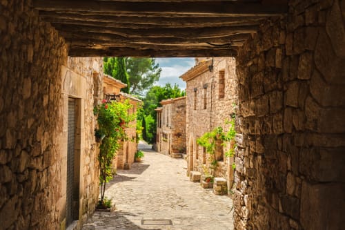 Encantador callejón de piedra en Priorat, Tarragona, con muros cubiertos de hiedra y arquitectura tradicional cerca de Hotel El Balco del