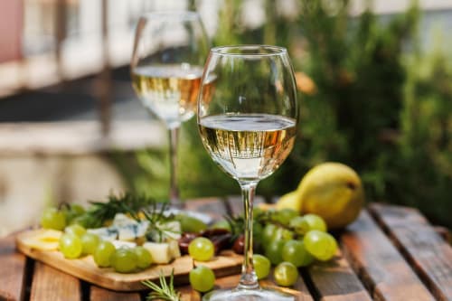 Copas de vino blanco con uvas y queso en la terraza del Hotel El Balco del Priorat, Tarragona