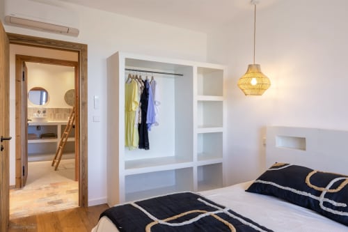 Chambre moderne de la villa CONSTANCE à La Conciergerie du Cap Corse avec penderie intégrée, luminaires suspendus et salle de bains privée