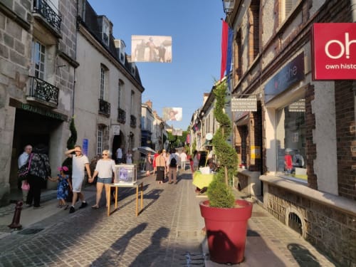Charmante rue piétonne à Saint-Escobille avec commerces, galeries et jardinières rouges près d'Espaces Gîtes