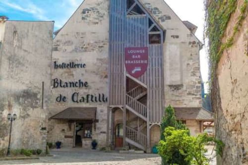 Espaces Gîtes BnB à Saint-Escobille : bâtiment historique en pierre, enseigne Blanche de Castille et bar lounge moderne