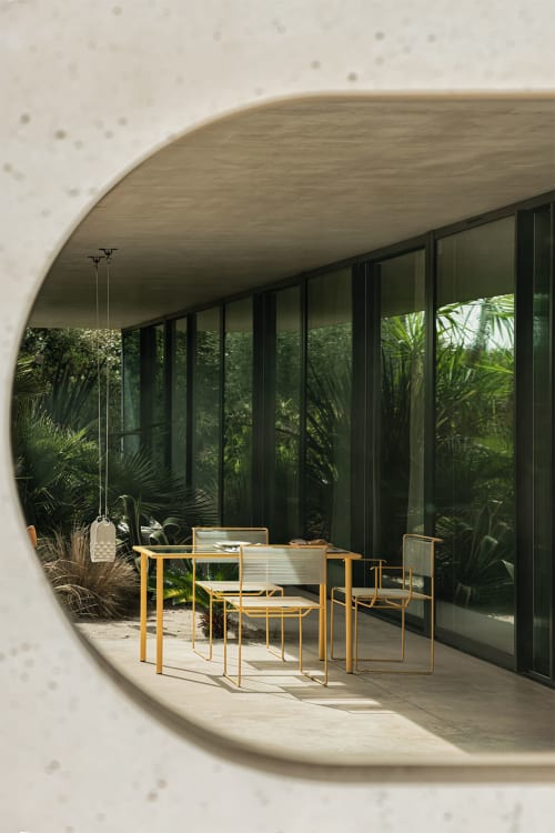 Patio de la Maison Jalon avec mobilier de salle à manger en bois, plantes tropicales et baies vitrées à Aix-en-Provence
