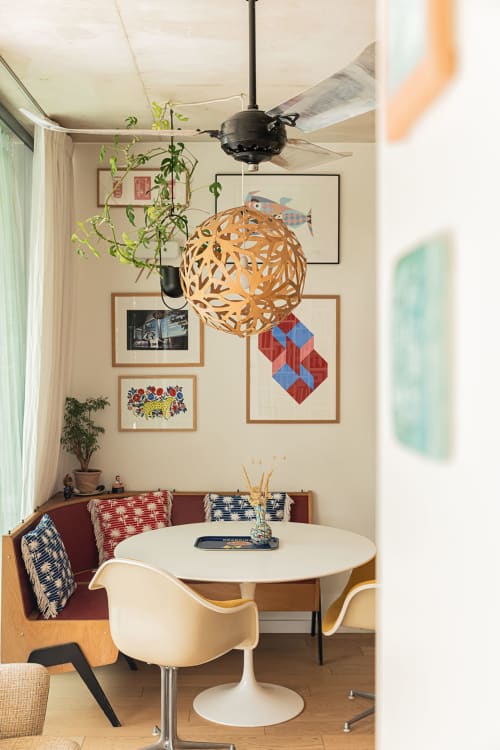 Coin repas cosy à la Maison Jalon B&B d'Aix-en-Provence avec table ronde, chaises crème et décoration murale artistique.