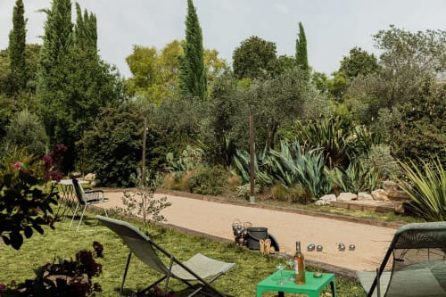 Jardin de la Maison Jalon avec terrain de pétanque, chaises longues et paysagisme méditerranéen à Aix-en-Provence