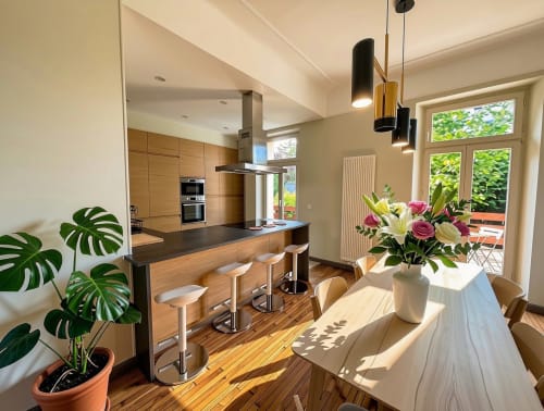 Modern open-plan kitchen and dining area at Mattbnb Villa58 in Metz, France, with wooden cabinetry and natural light