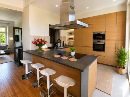 Modern luxury kitchen with wooden cabinetry, island seating, and stainless steel appliances at Villa58 in Metz