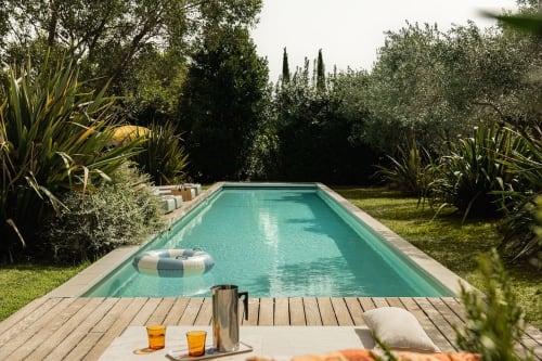 Piscine élégante aux eaux turquoise, entourée de jardins luxuriants à la Villa Maison Jalon à Aix-en-Provence.