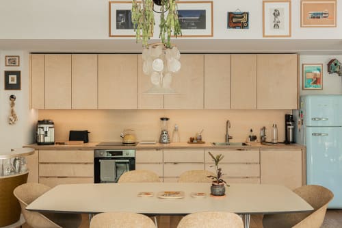 Cuisine et salle à manger modernes de la villa Maison Jalon à Aix-en-Provence, avec mobilier en bois clair et réfrigérateur turquoise