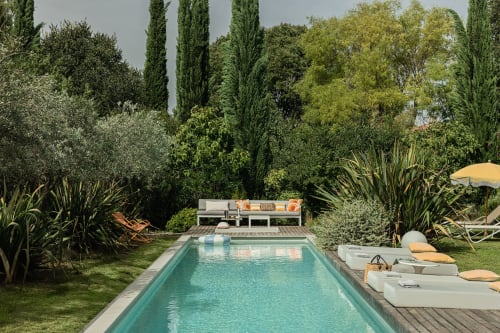 Piscine luxueuse de la villa Maison Jalon à Aix-en-Provence avec chaises longues, jardins méditerranéens et voile d'ombrage