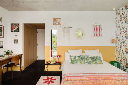 Chambre lumineuse à la villa Maison Jalon à Aix-en-Provence avec tête de lit jaune, décoration florale et accès au balcon