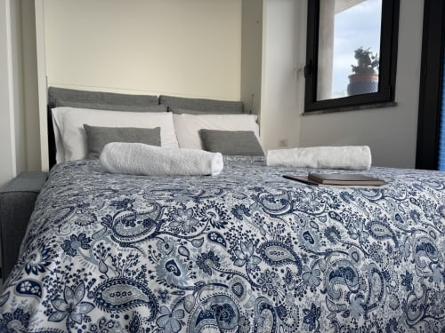 Letto matrimoniale premium con biancheria paisley blu presso Aurora View Resort, Italia, con balcone affacciato sul mare