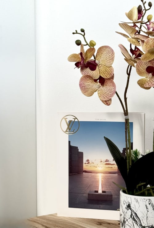 Elegante composizione di orchidee con libro di paesaggi desertici presso Aurora View Resort, esclusiva meta balneare italiana