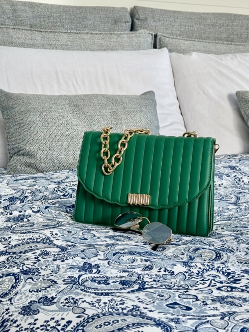 Borsa a spalla trapuntata verde con catena dorata su tessuti decorativi presso Aurora View Resort, Italia
