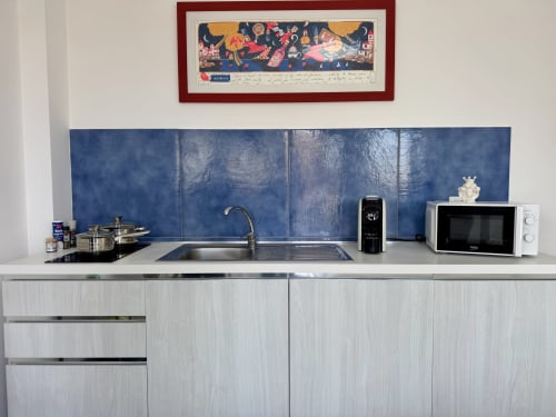 Cucina moderna con rivestimento blu, lavello, microonde e accessori da cucina presso Aurora View Resort, Italia