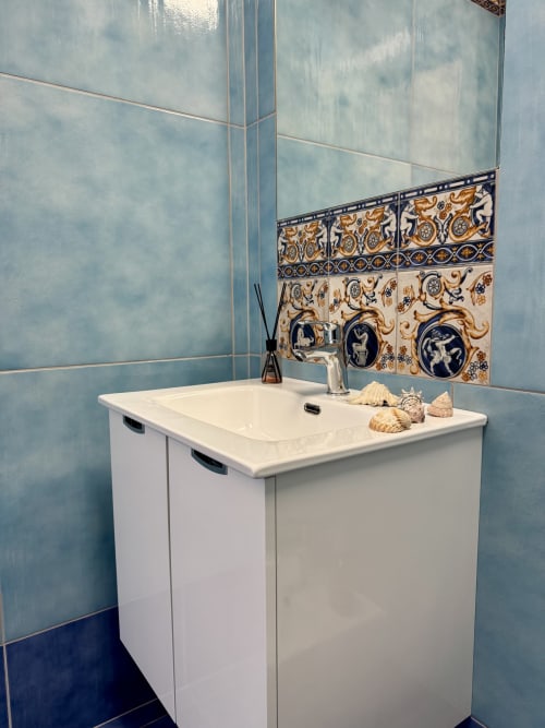 Bagno moderno con mobile lavabo bianco, rubinetto cromato e rivestimento decorativo in piastrelle blu presso Aurora View Resort