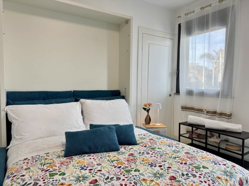 Camera matrimoniale premium Aurora View Resort con balcone vista mare, biancheria floreale e comfort moderni