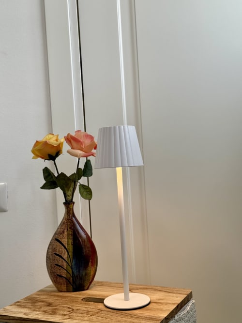 Vaso decorativo con rose gialle e corallo e moderna lampada da terra bianca su tavolo in legno nella camera premium di Aurora View Resort