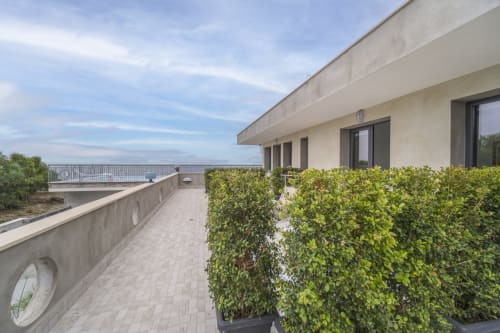Terrazza moderna dell'Aurora View Resort con vista sul mare, siepi in vaso e architettura contemporanea che si affaccia su paesaggi italiani