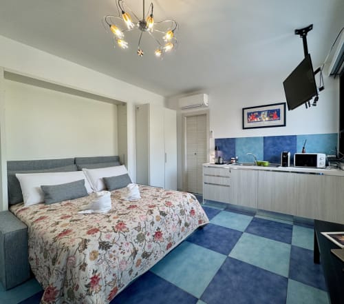 Camera deluxe presso Aurora View Resort con letto queen, angolo cottura, TV schermo piatto e pavimenti geometrici blu