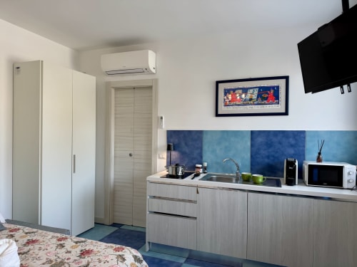 Camera Deluxe Aurora View Resort con angolo cottura moderno, rivestimento in piastrelle blu, climatizzazione, TV a schermo piatto e arredamento contemporaneo